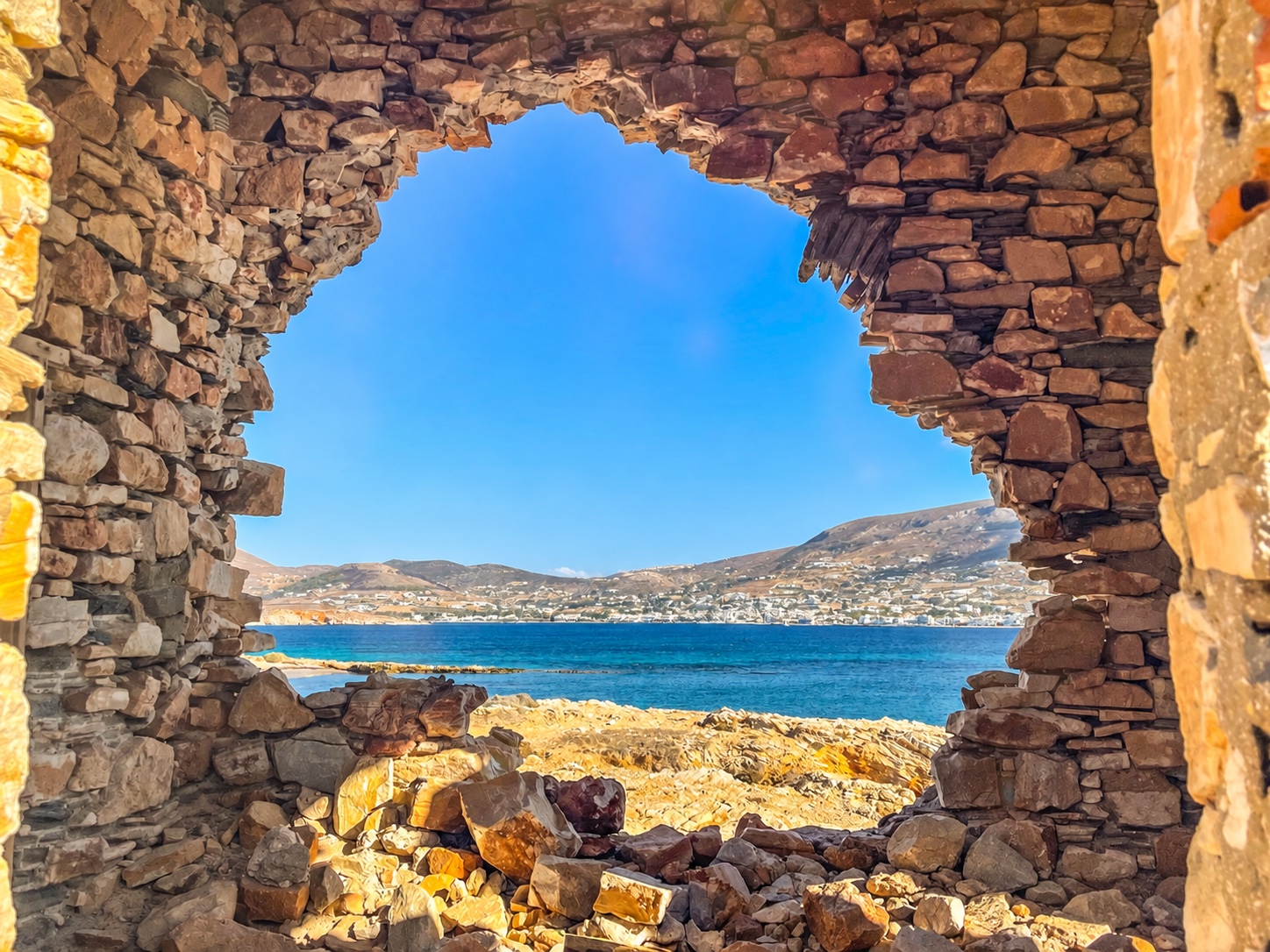 Vue sur la mer Égée à travers une ouverture en pierre